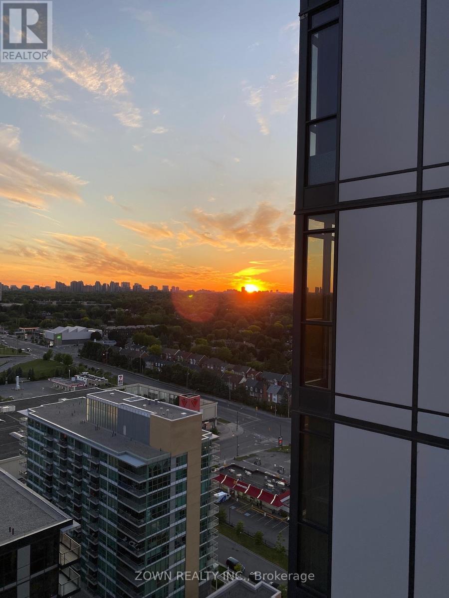 A sunset view from a high-rise building with the sun visible through the clouds.