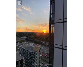 A sunset view from a high-rise building with the sun visible through the clouds.