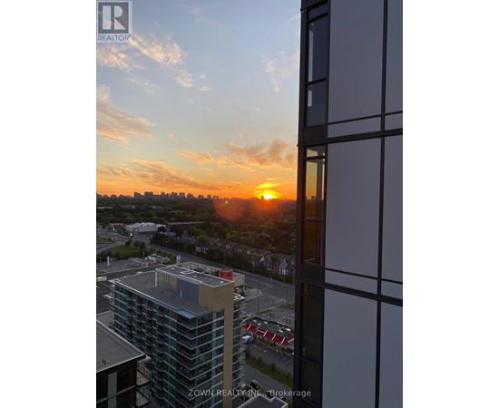 A sunset view from a high-rise building with the sun visible through the clouds.