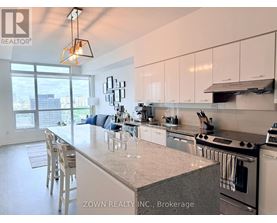 A kitchen with a large island and a view of the city.