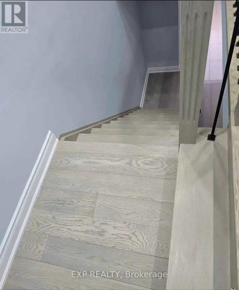 A staircase with wooden steps and a grey wall.