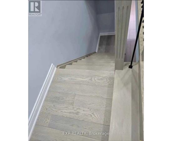A staircase with wooden steps and a grey wall.