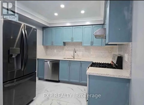 A kitchen with blue cabinets and a stainless steel refrigerator.