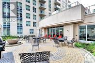 A patio with chairs and a table is in front of a building.