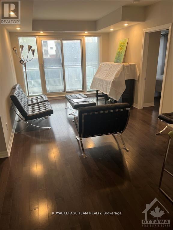 A living room with a black couch and a white chair.