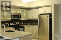 A kitchen with a refrigerator, microwave, and oven.
