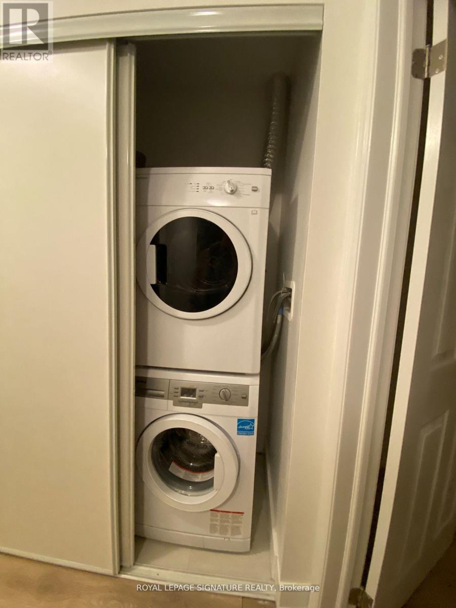 A white dryer and washer are in a cabinet.
