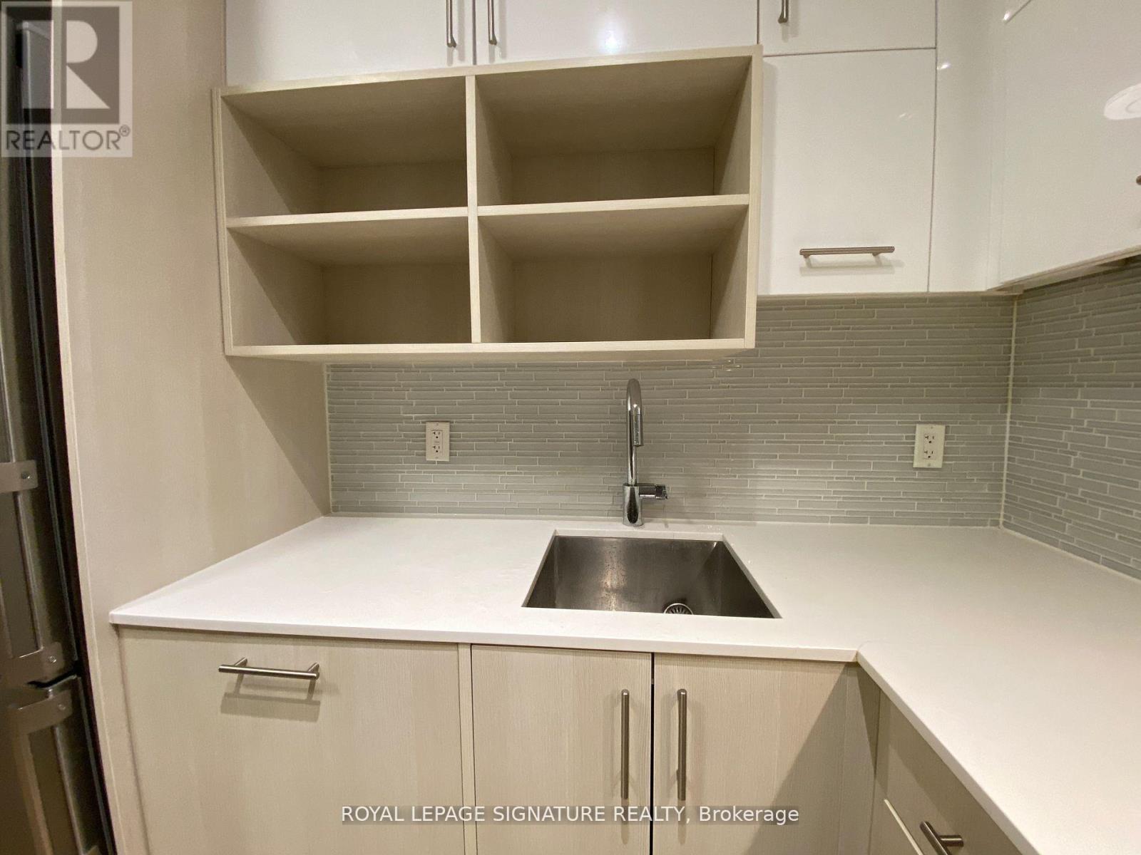 A kitchen with white cabinets and a sink.