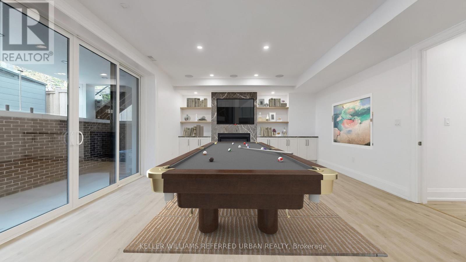 A pool table is in the middle of a room with a glass wall.