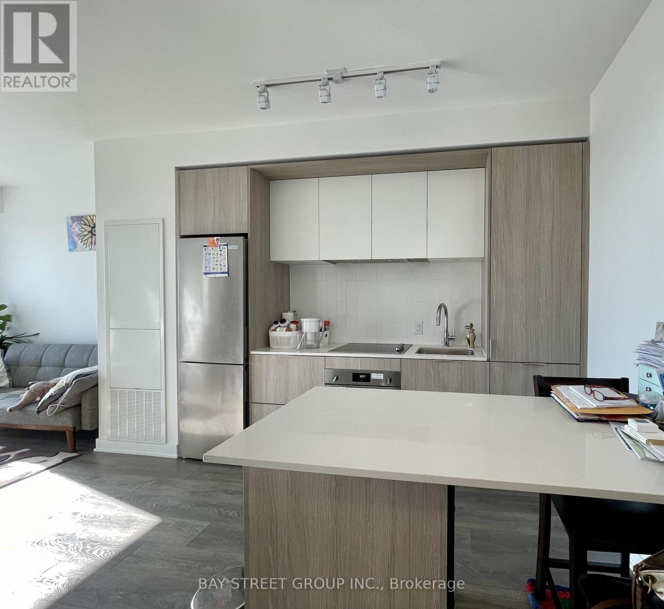 A modern kitchen with a refrigerator, sink, and cabinets.