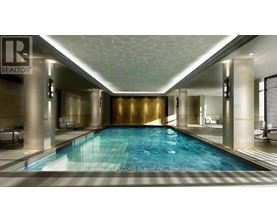 A large indoor swimming pool with a gold wall and a white ceiling.