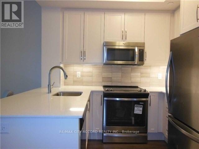 A kitchen with white cabinets and a stainless steel refrigerator.