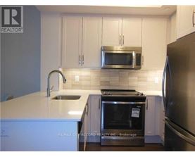 A kitchen with white cabinets and a stainless steel refrigerator.
