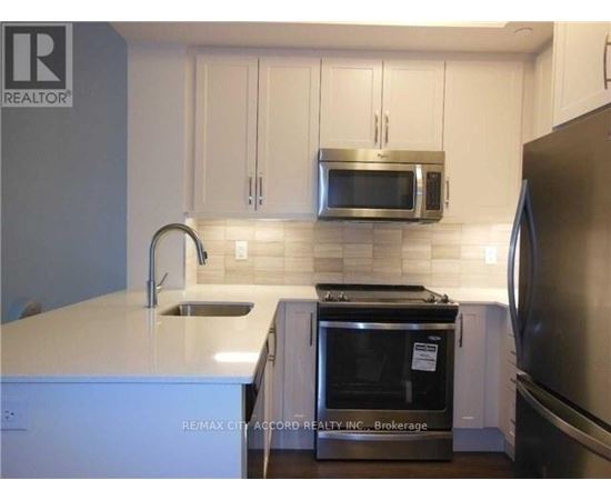 A kitchen with white cabinets and a stainless steel refrigerator.