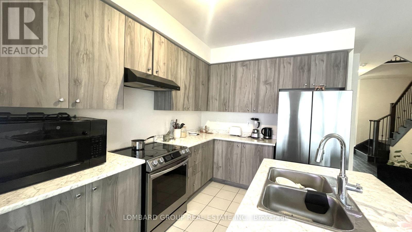 A modern kitchen with a black oven and wooden cabinets.