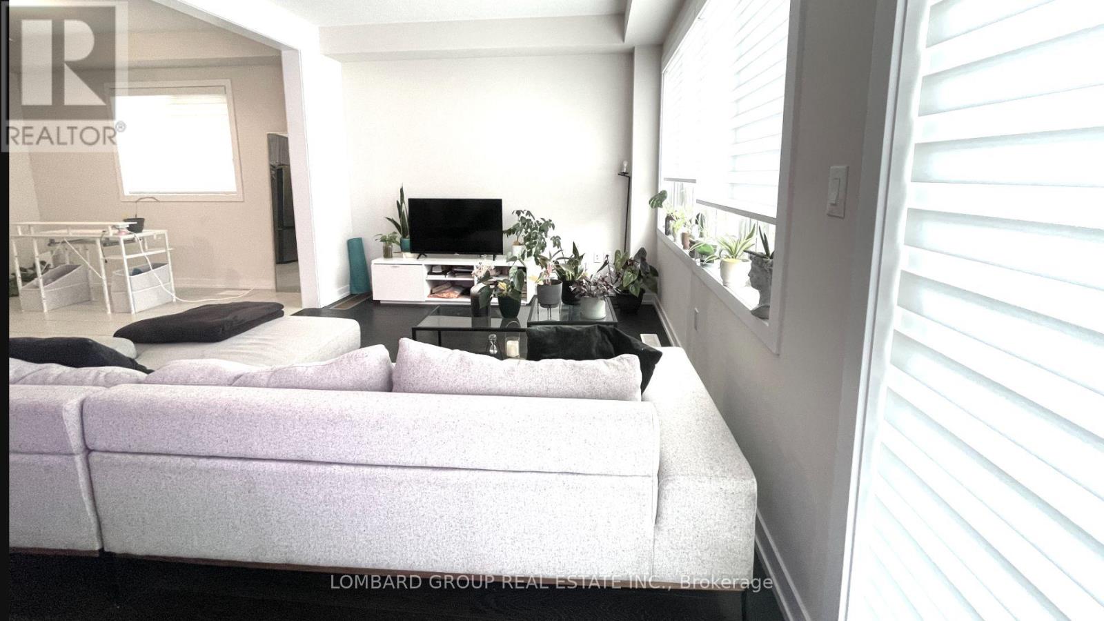 A living room with a white couch and a television.
