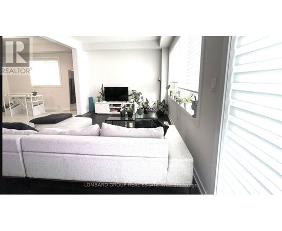 A living room with a white couch and a television.
