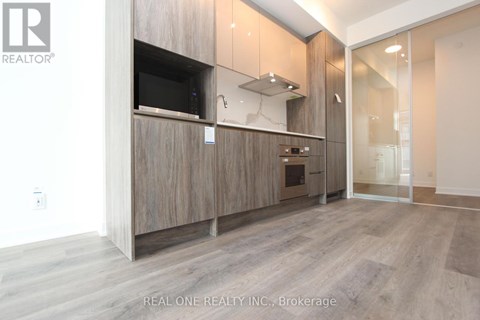 A modern kitchen with wooden cabinets and a glass door.