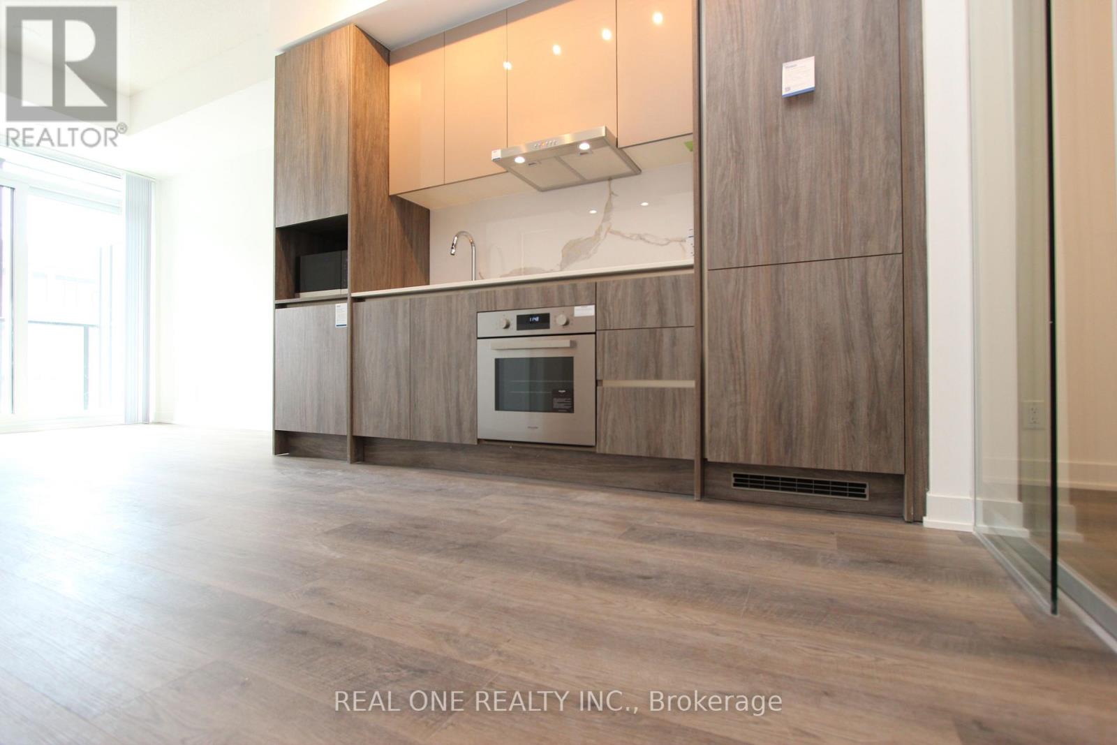A modern kitchen with wooden cabinets and a glass door oven.