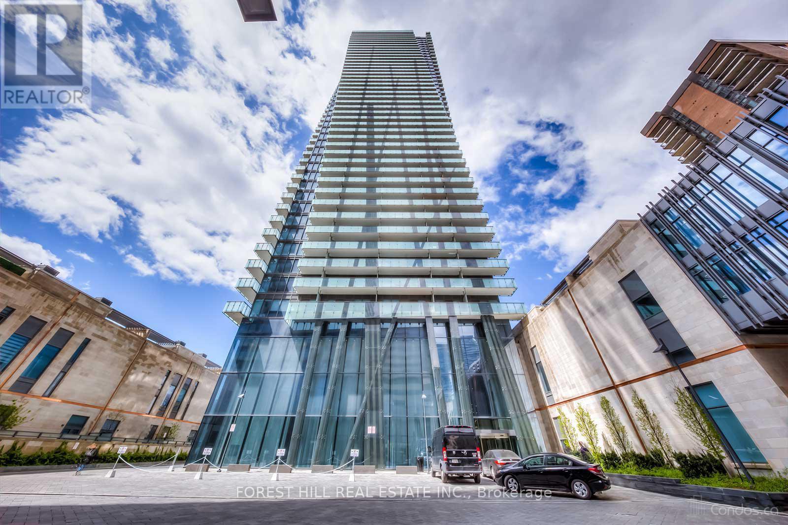 A tall glass building with a car parked in front of it.