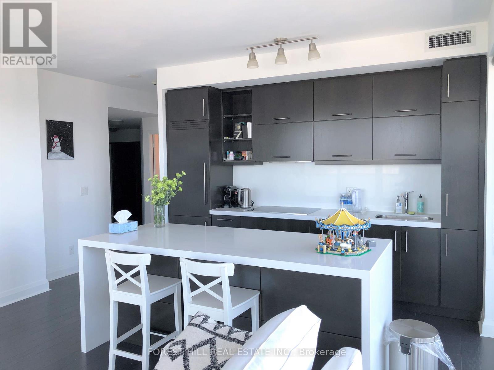 A kitchen with white cabinets and a white island with a yellow umbrella on it.