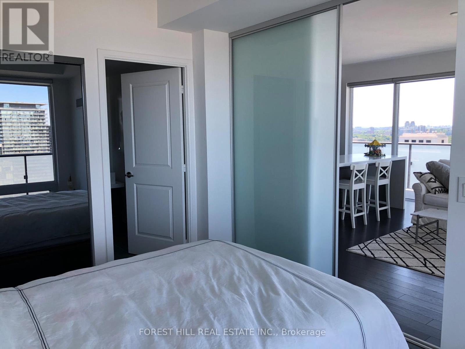 A bedroom with a large bed and a view of the water.