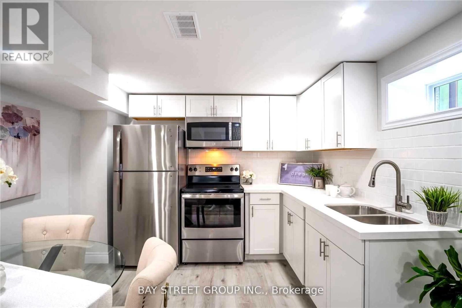 A modern kitchen with white cabinets and stainless steel appliances.