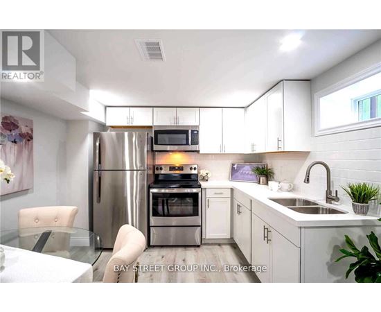 A modern kitchen with white cabinets and stainless steel appliances.