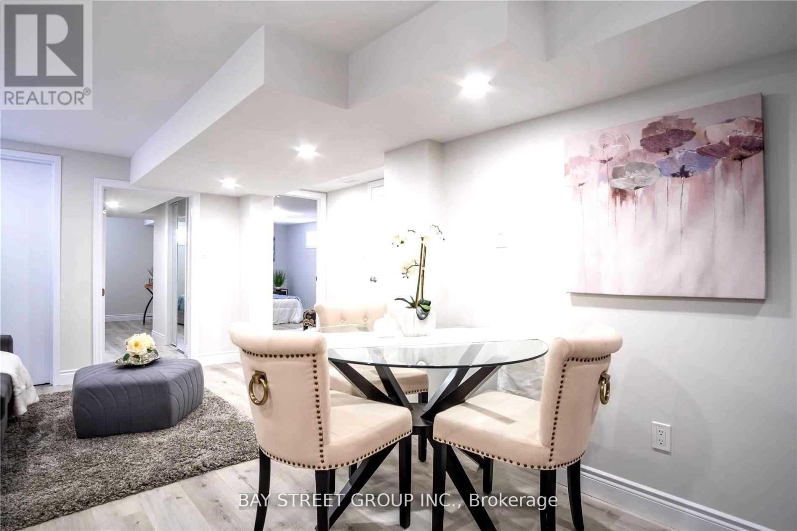 A dining room with a table set for two and a painting on the wall.
