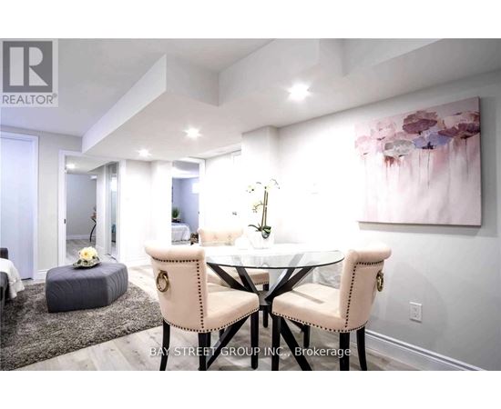 A dining room with a table set for two and a painting on the wall.