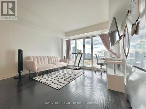 A living room with a white sofa and a black floor lamp.