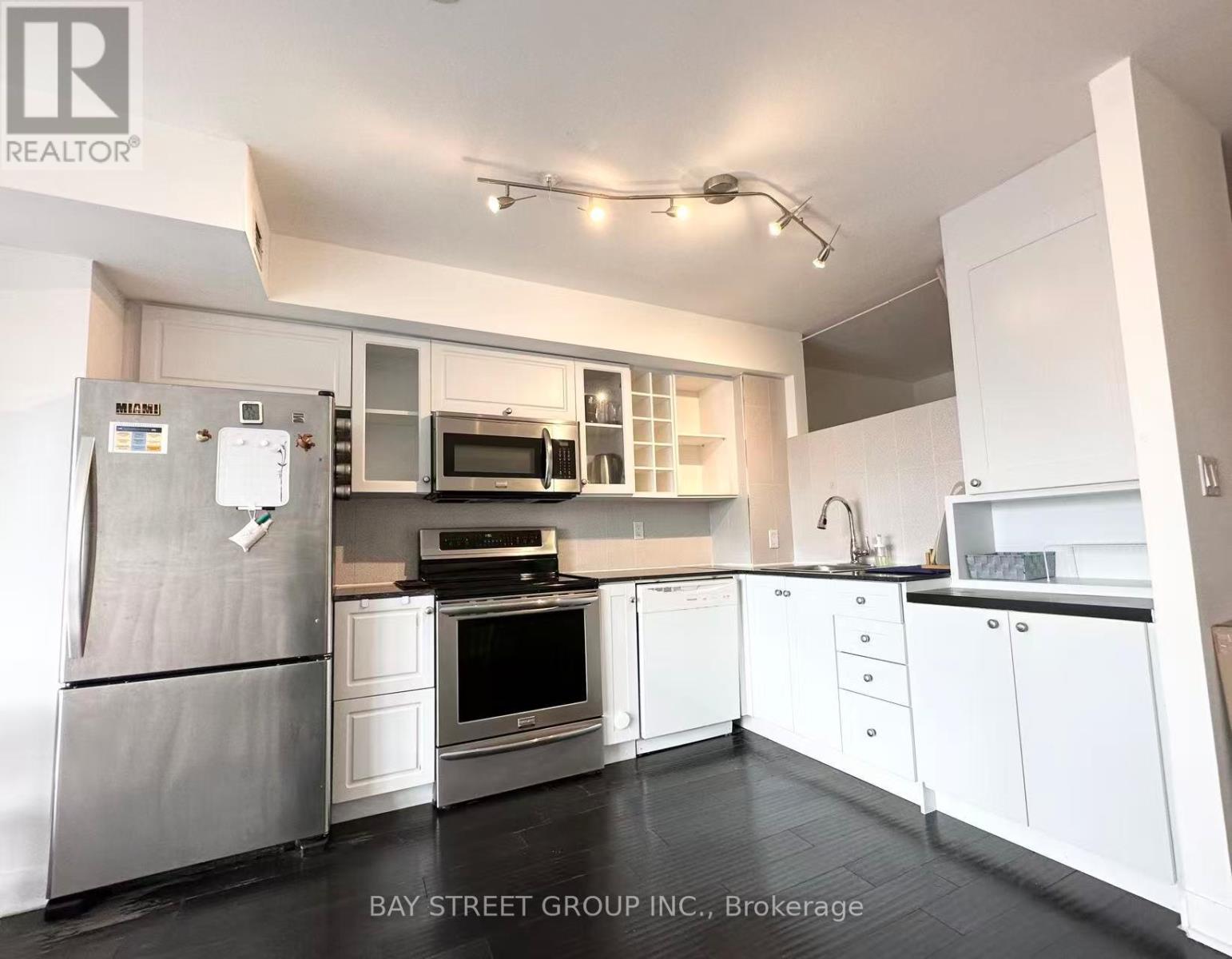 A modern kitchen with white cabinets and stainless steel appliances.