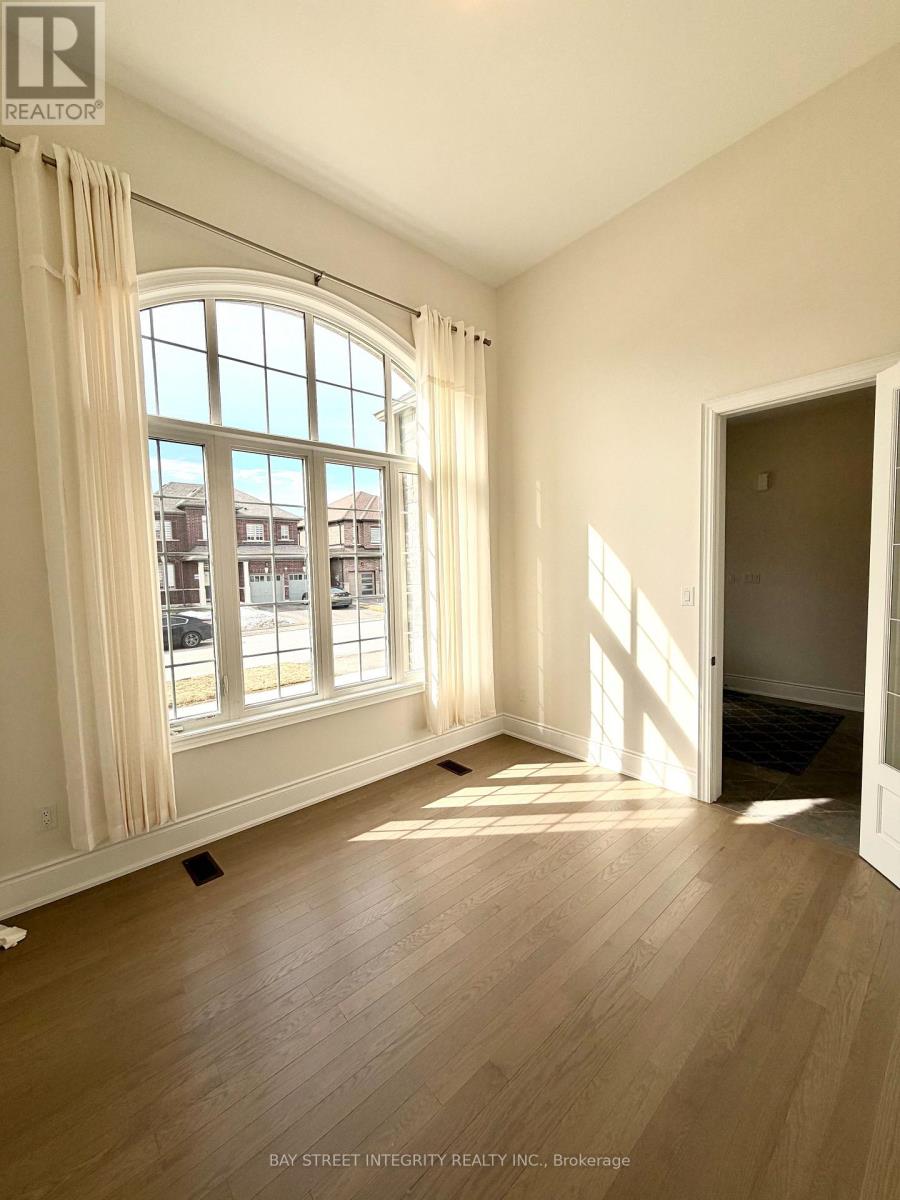 A room with a large window and wooden flooring.