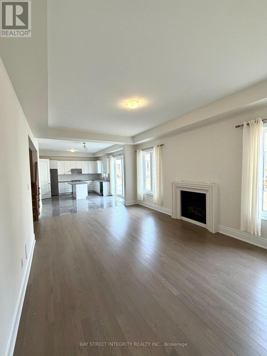 A spacious living room with a fireplace and a dining area in the background.