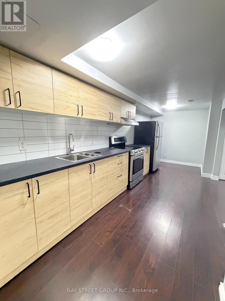 A kitchen with wooden cabinets and black countertops.