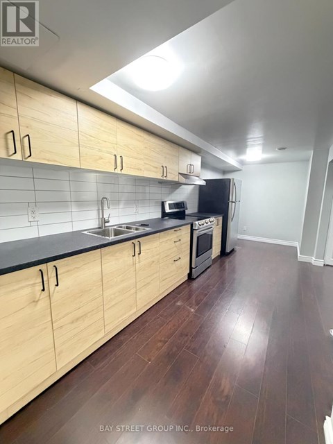 A kitchen with wooden cabinets and black countertops.