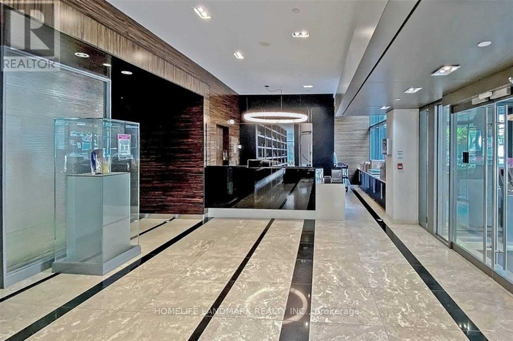 A spacious lobby with a marble floor and a glass wall.