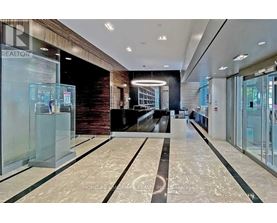 A spacious lobby with a marble floor and a glass wall.