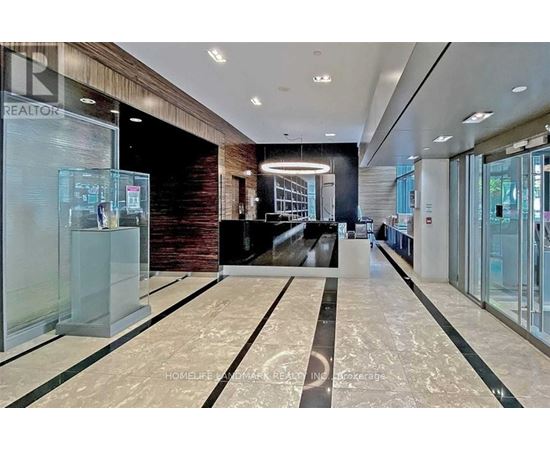 A spacious lobby with a marble floor and a glass wall.