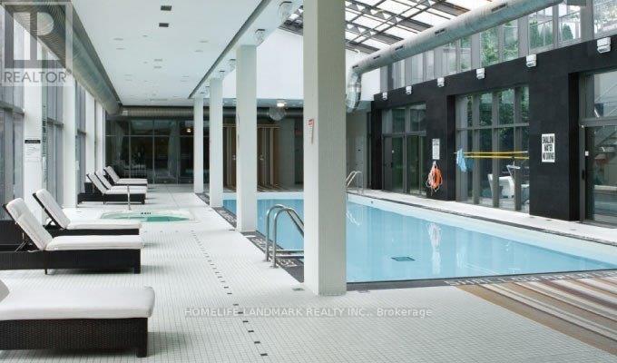 A pool area with sun loungers and a glass ceiling.