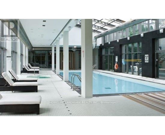 A pool area with sun loungers and a glass ceiling.