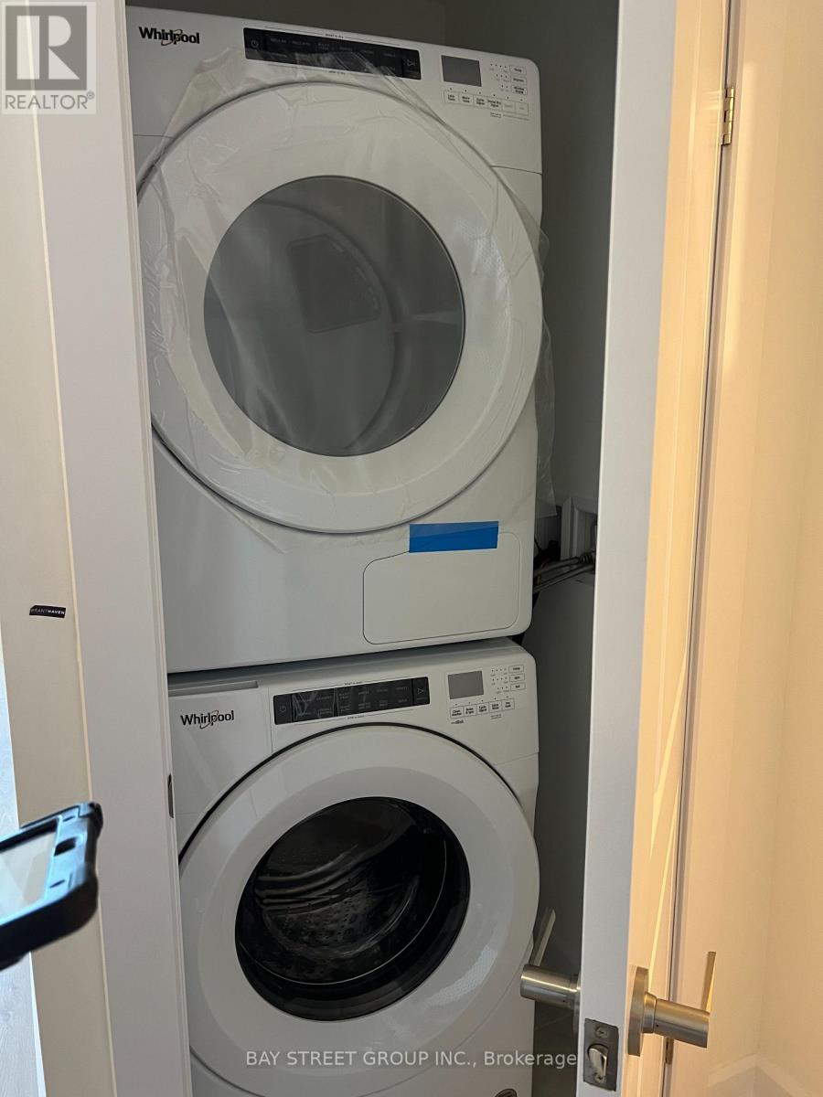 A white Whirlpool washing machine is in a small cabinet.