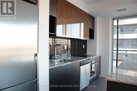 A modern kitchen with a stainless steel refrigerator and a marble countertop.
