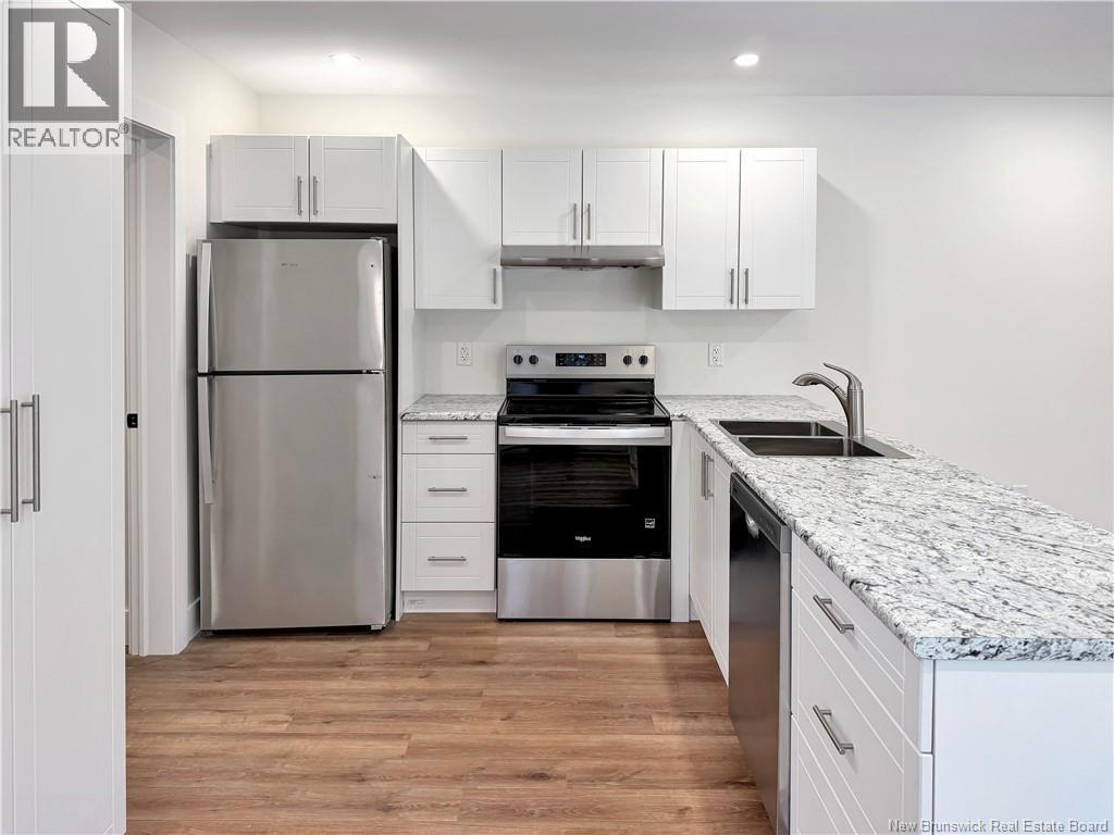 A kitchen with a refrigerator, oven, and cabinets.