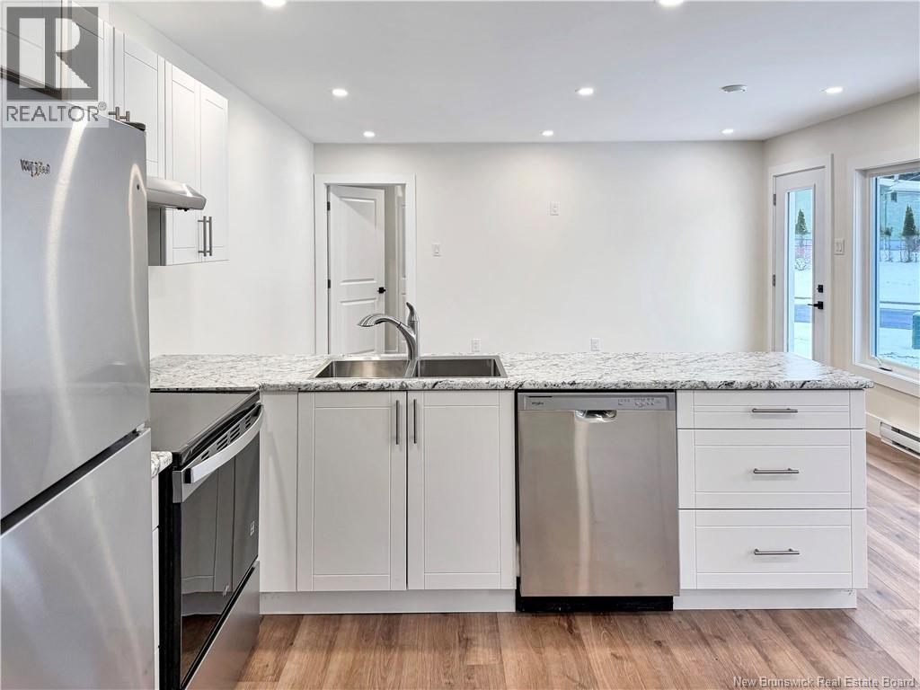 A modern kitchen with white cabinets and stainless steel appliances.