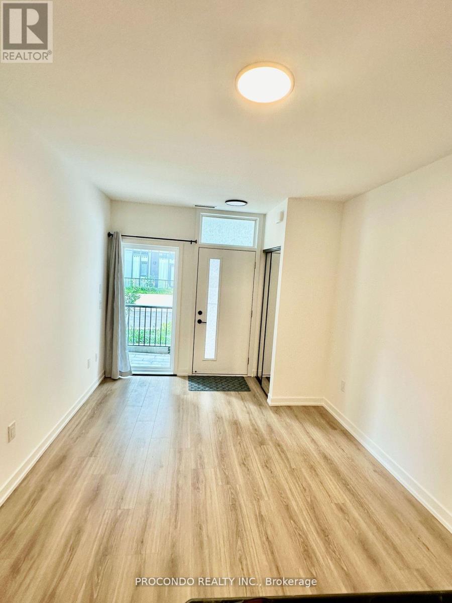 A room with wooden flooring and a sliding glass door leading to a balcony.
