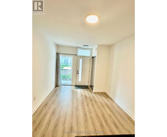 A room with wooden flooring and a sliding glass door leading to a balcony.