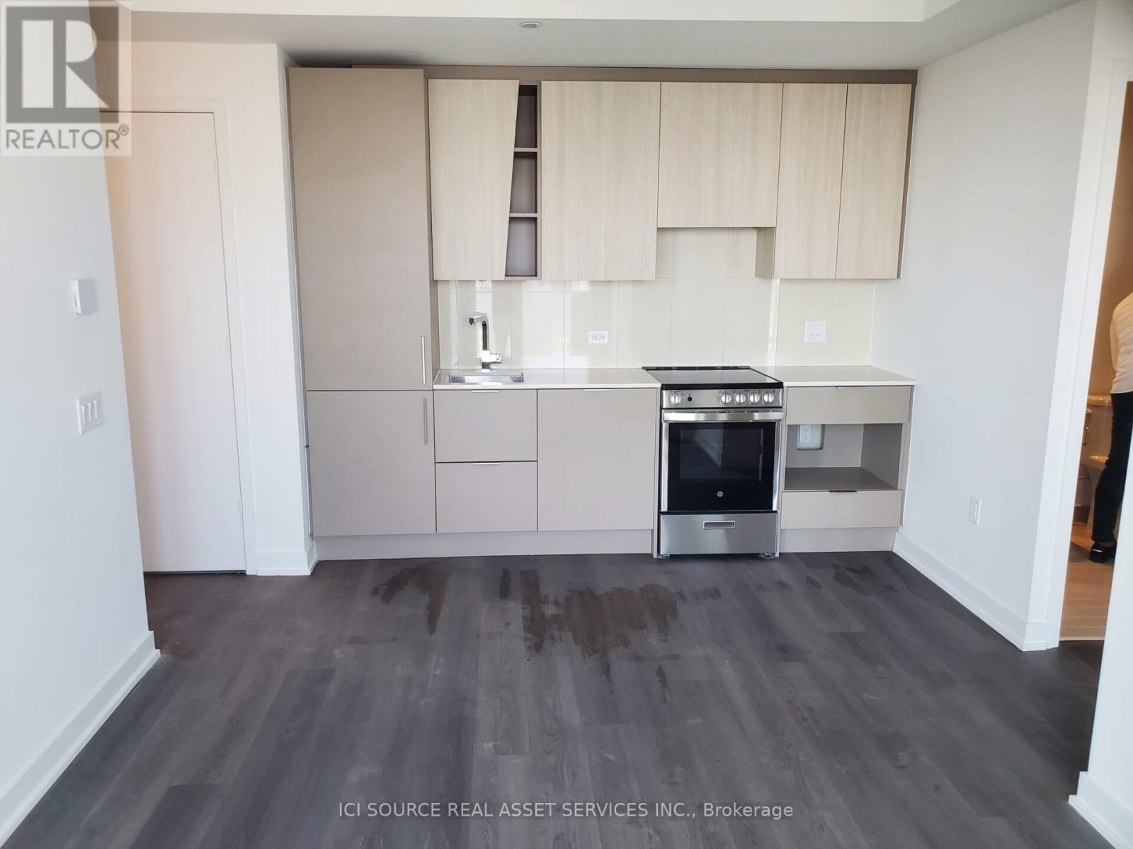 A kitchen with a stove top oven and a refrigerator.