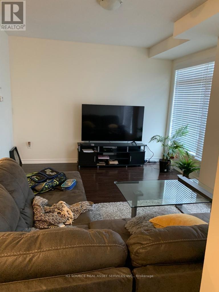 A living room with a brown couch and a television.