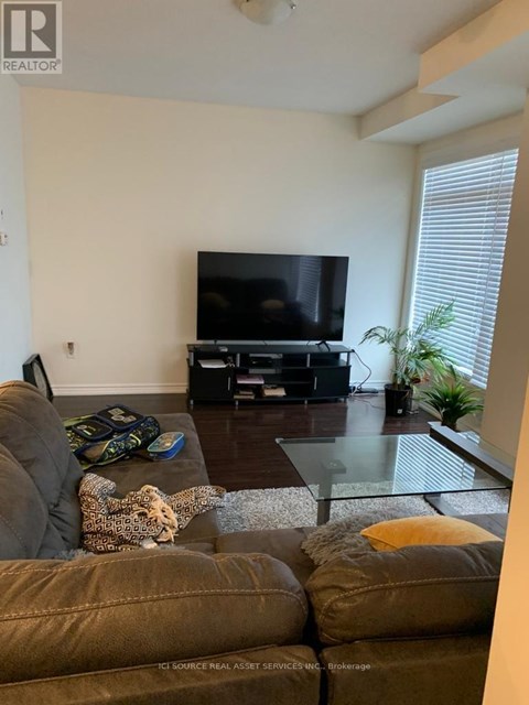 A living room with a brown couch and a television.